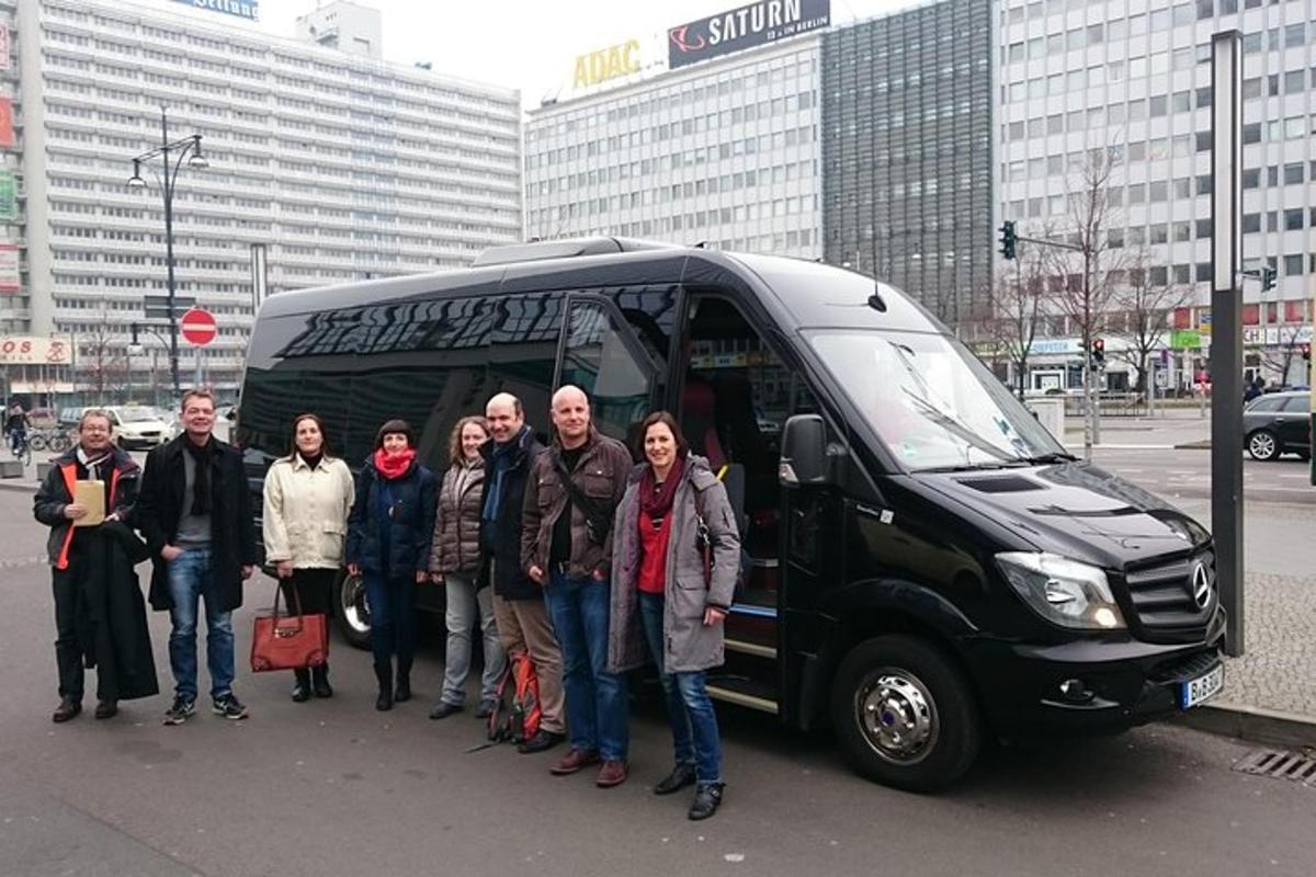 um grupo de pessoas em pé na frente de um ônibus