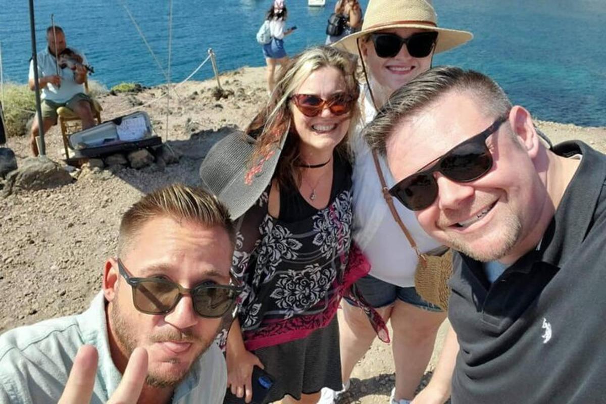 hópur fólks að pósa fyrir mynd á ströndinni