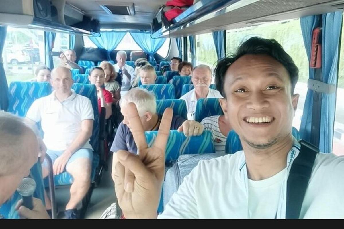 un home fent el senyal de la pau en un autobús