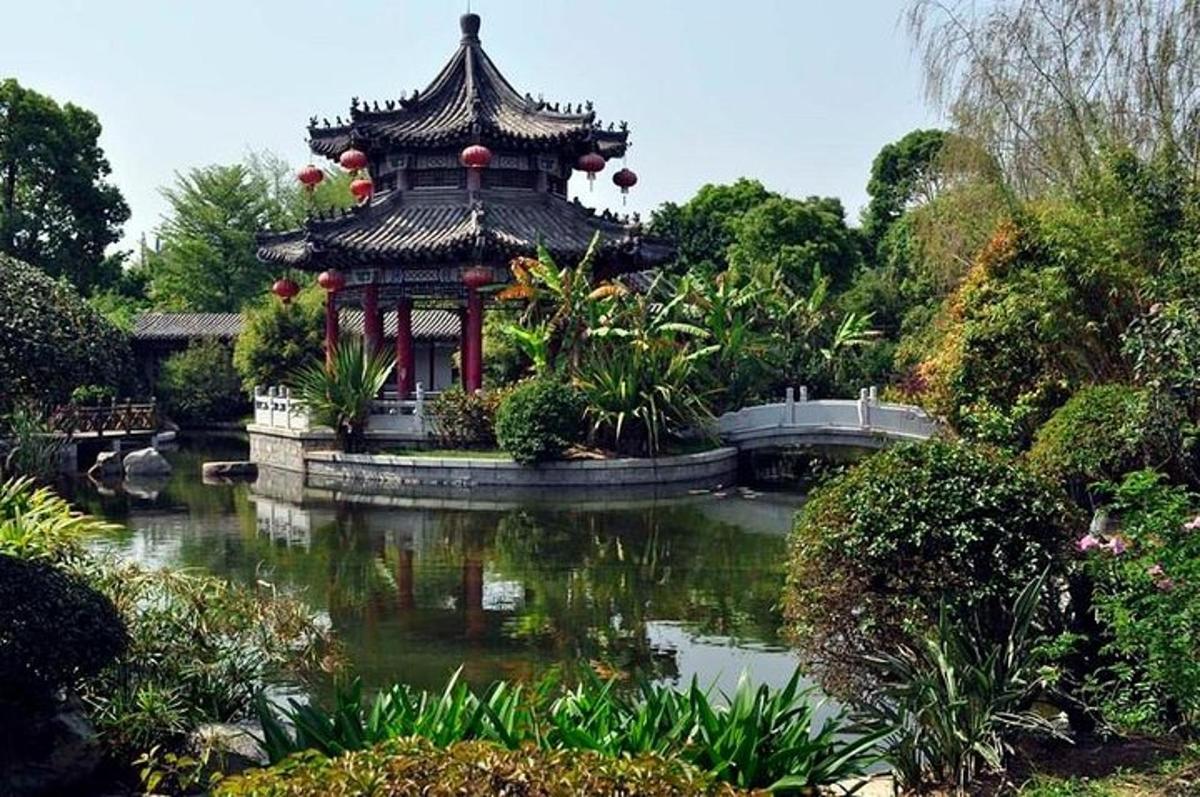 una pagoda in mezzo a uno stagno in un giardino