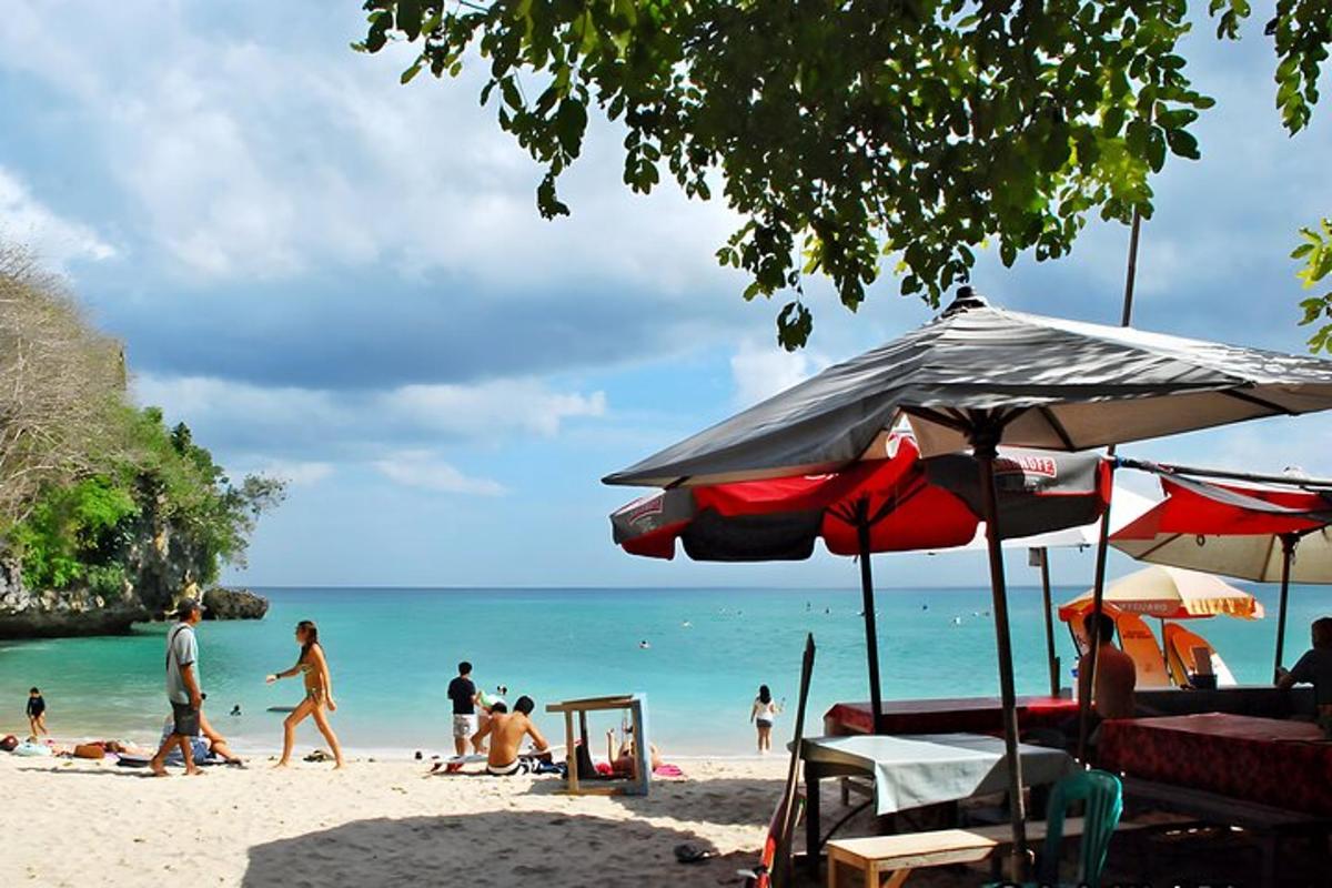 un grupo de personas en una playa con sombrillas