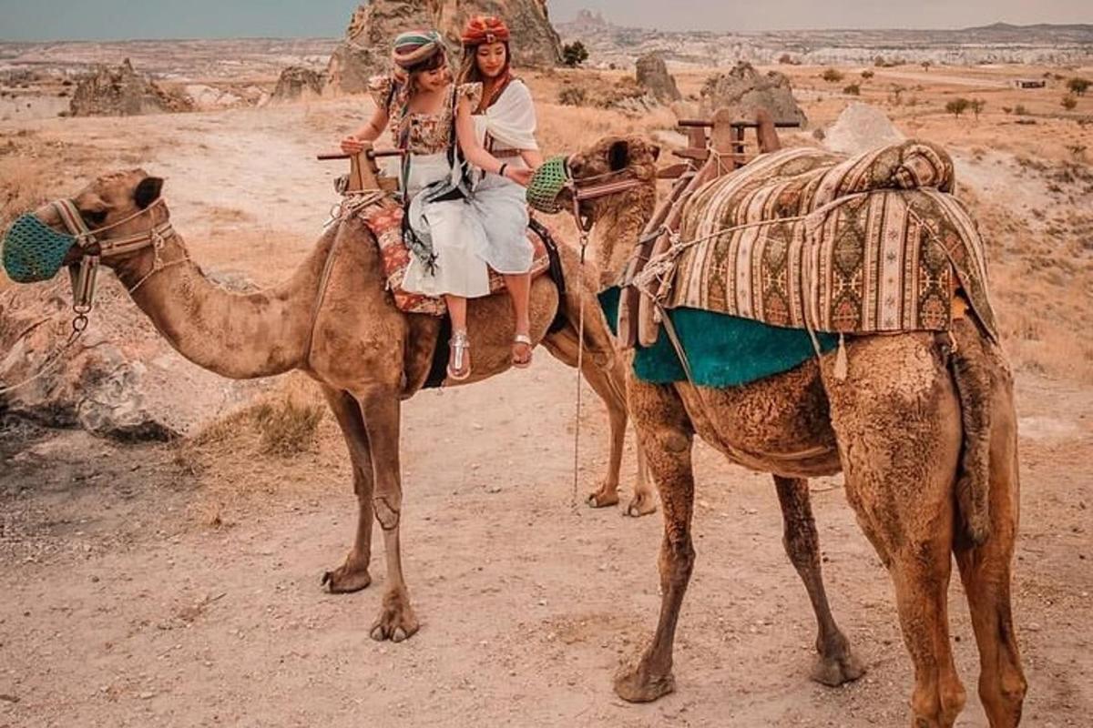 due persone a cavallo di un cammello nel deserto