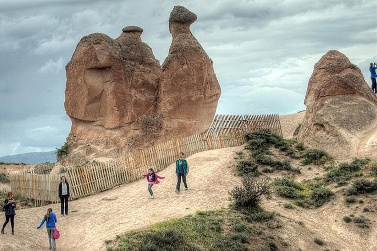 un gruppo di persone che camminano davanti a una formazione rocciosa