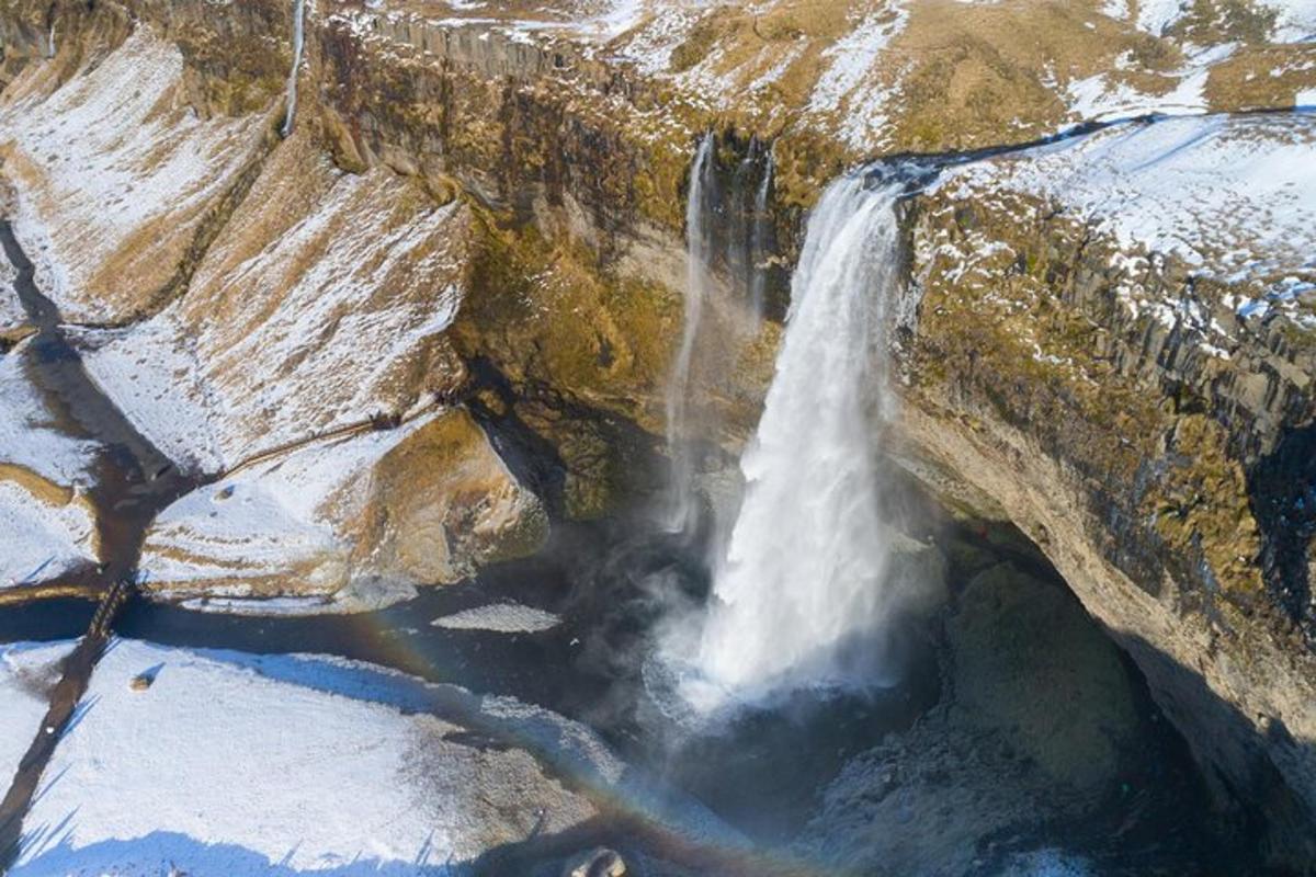 una cascada al vessant d'una muntanya amb neu