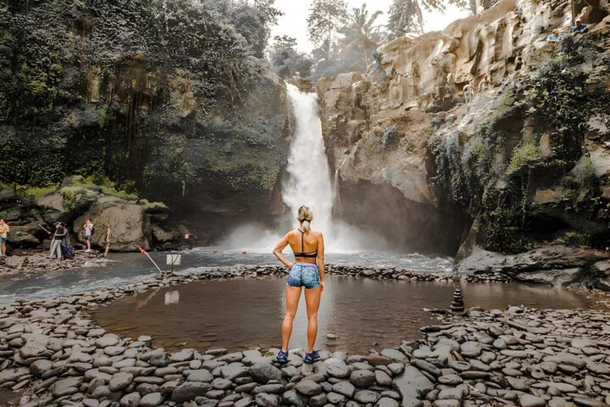 una dona dempeus davant d'una cascada