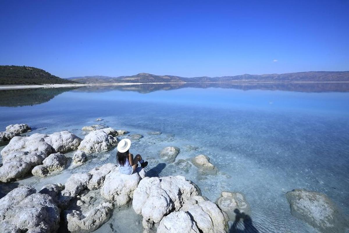 two people sitting on rocks in the water