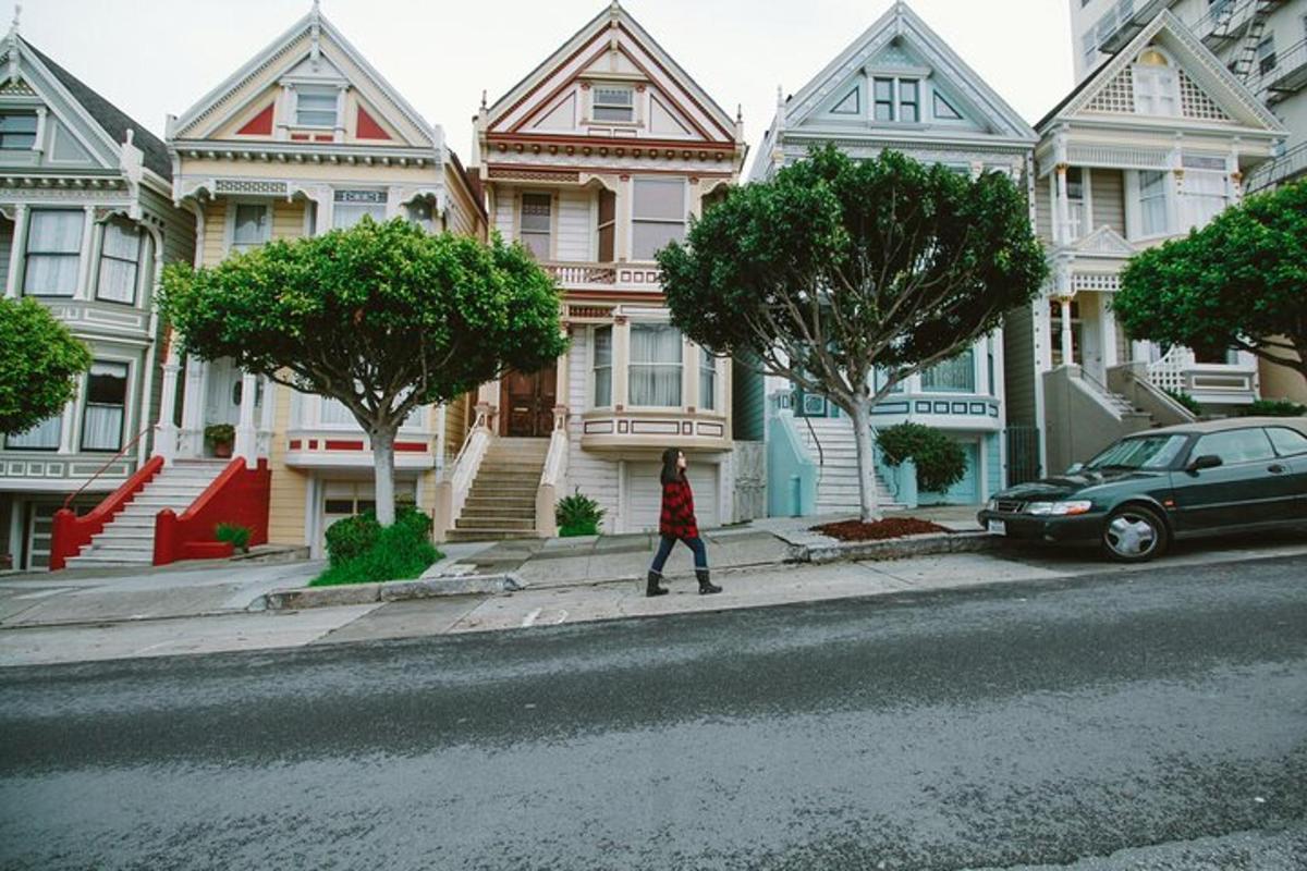 a woman walking down a street in front of houses