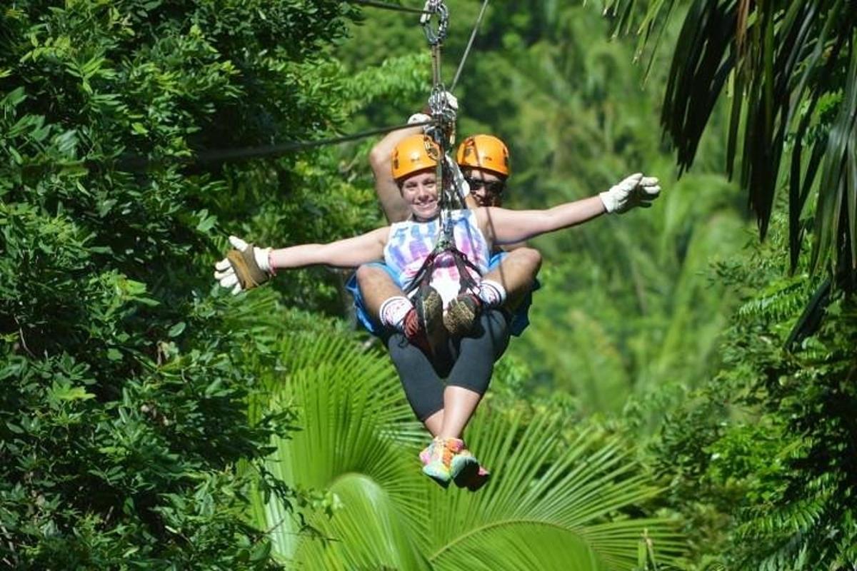 two people on a zip line in the jungle