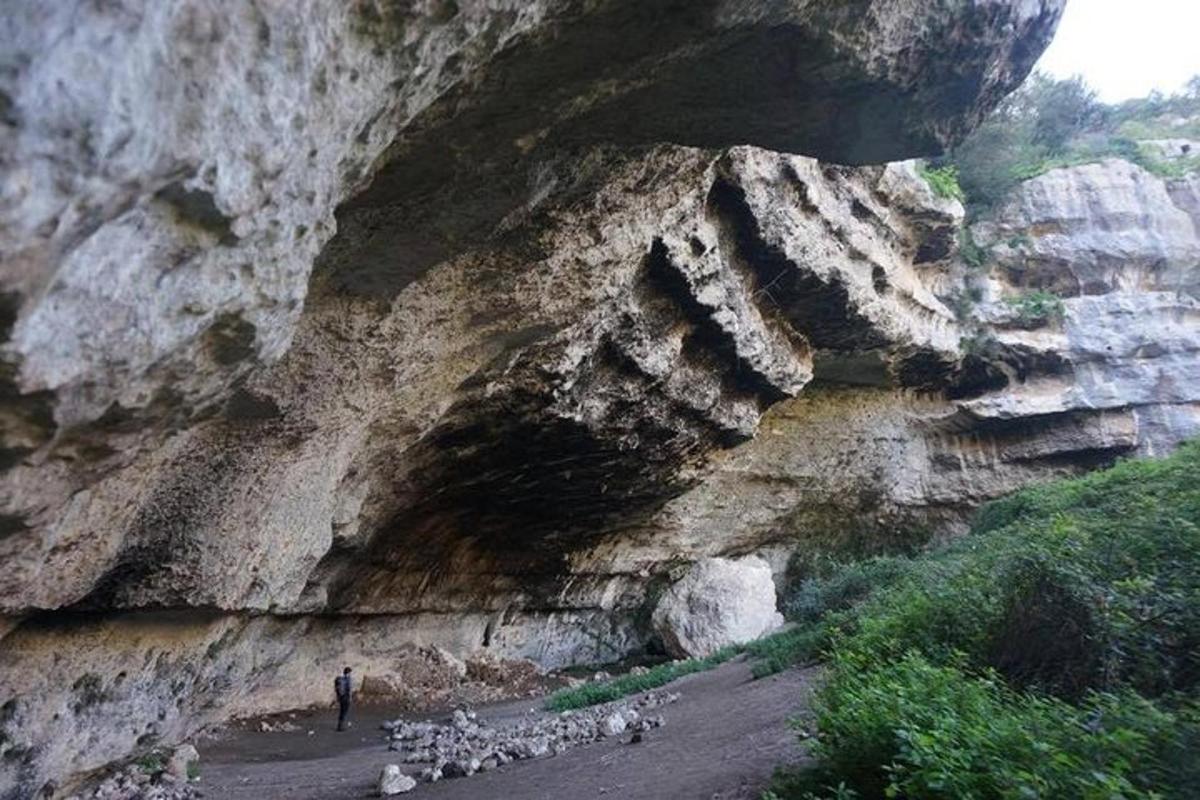 osoba stojící před skalnatou horou