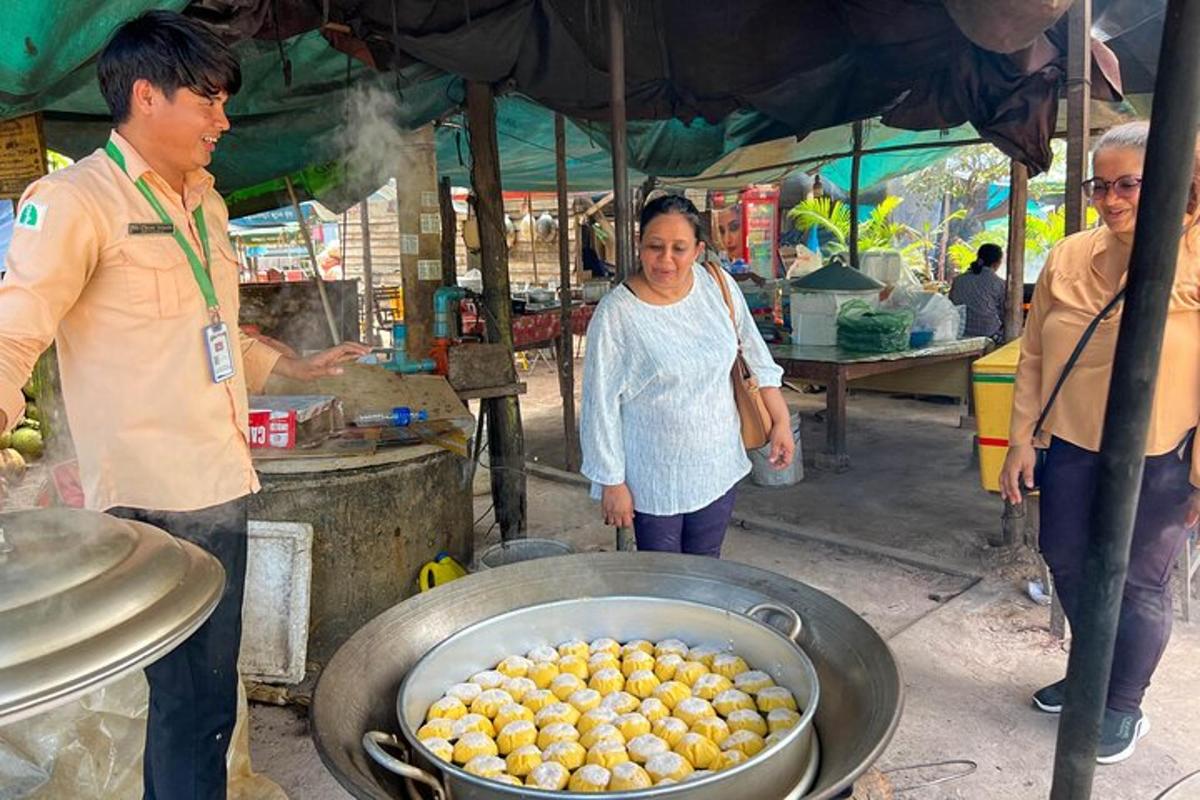 seorang lelaki dan seorang wanita berdiri di sebelah periuk makanan