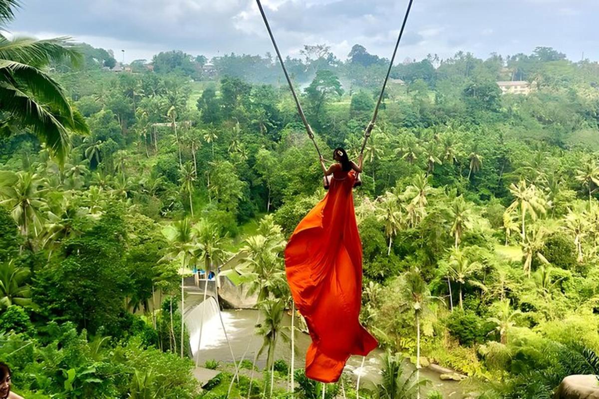 una donna con un vestito arancione che si dondola su una teleferica