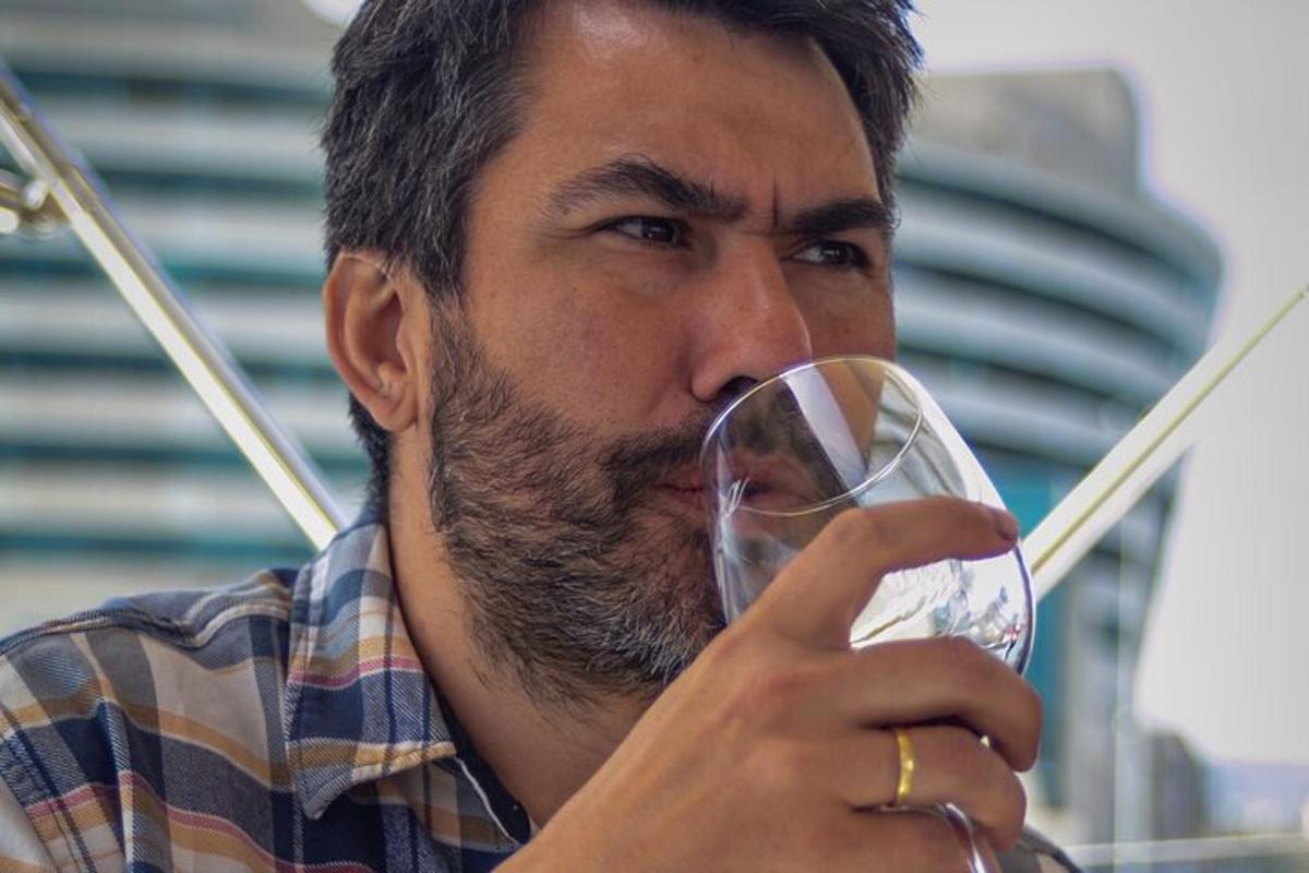 un home està bevent una copa de vi