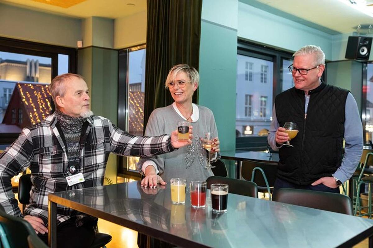 kolm inimest istuvad laua taga veiniklaase käes