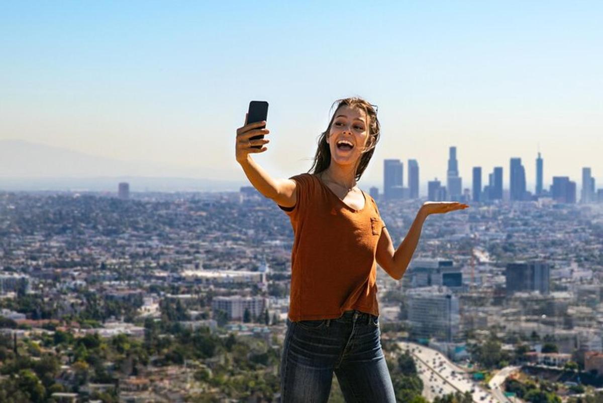 una donna che scatta una foto di una città con il suo cellulare