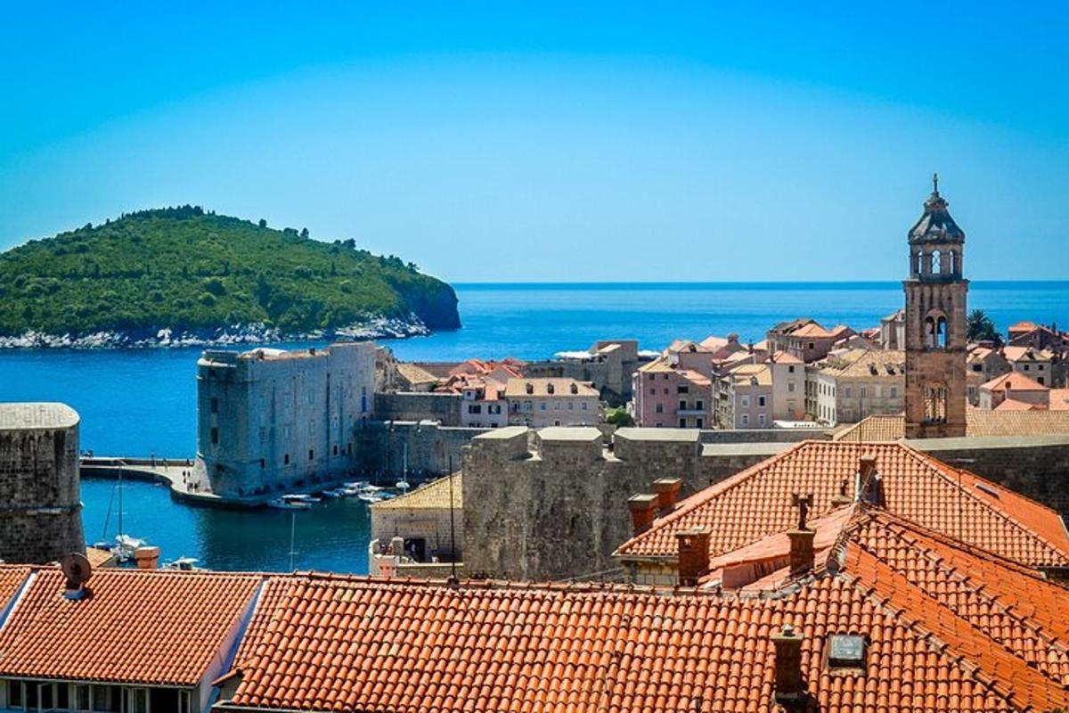 a view of a town with a clock tower and the ocean