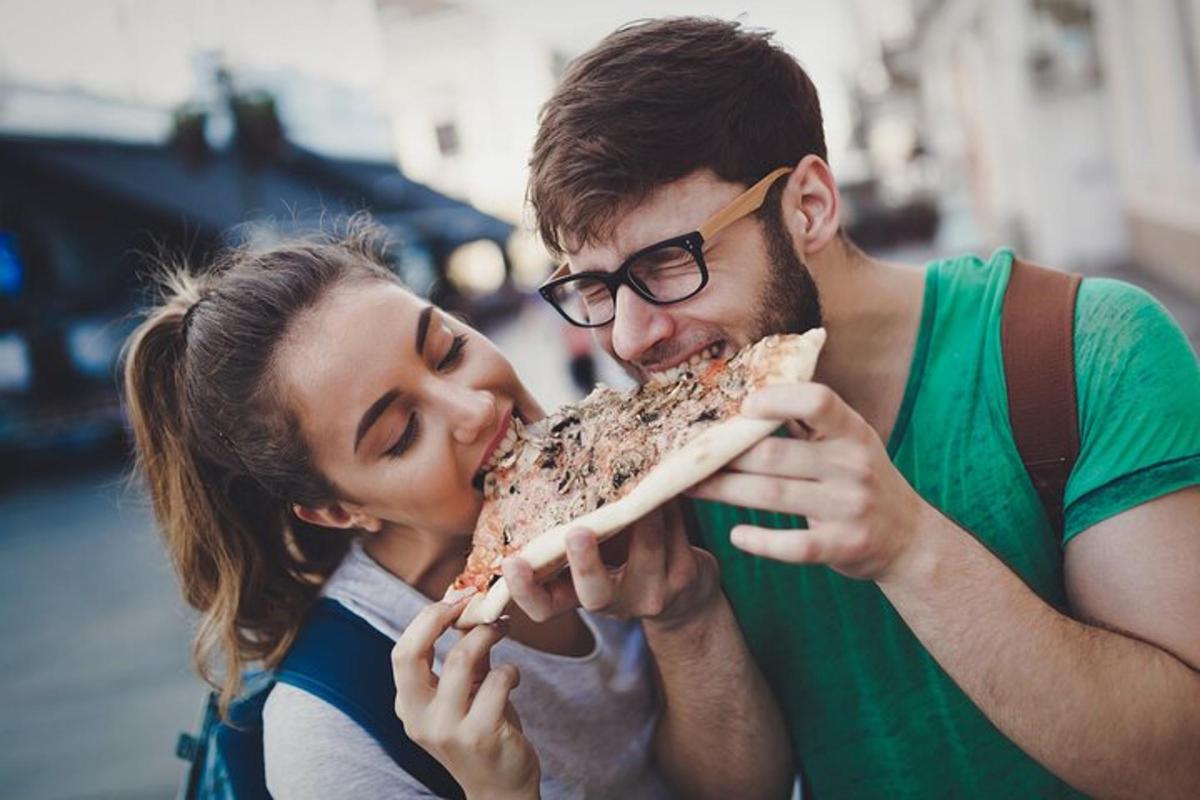 muž a žena jedí kousek pizzy