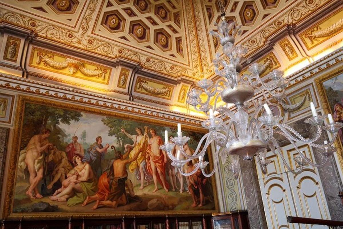 um lustre em uma sala com uma pintura no teto