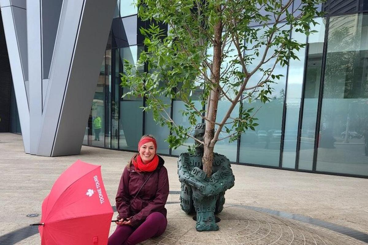 una mujer sentada en el suelo junto a un árbol