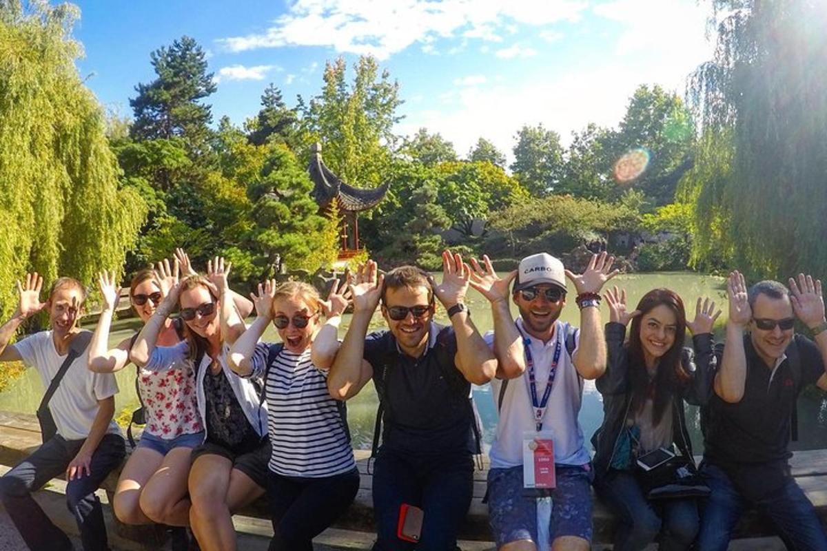 Un grupo de personas sentadas en un banco con las manos en el aire.