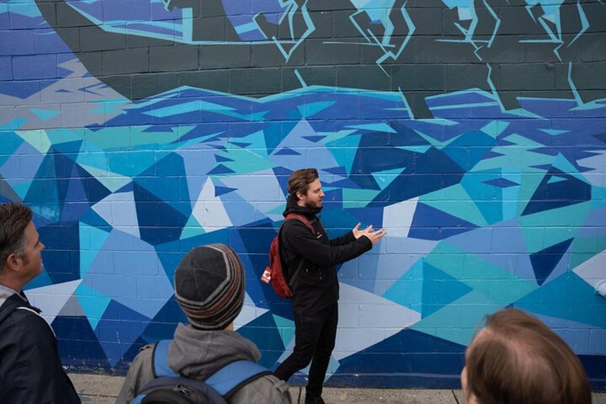 un homme se tient devant une peinture murale