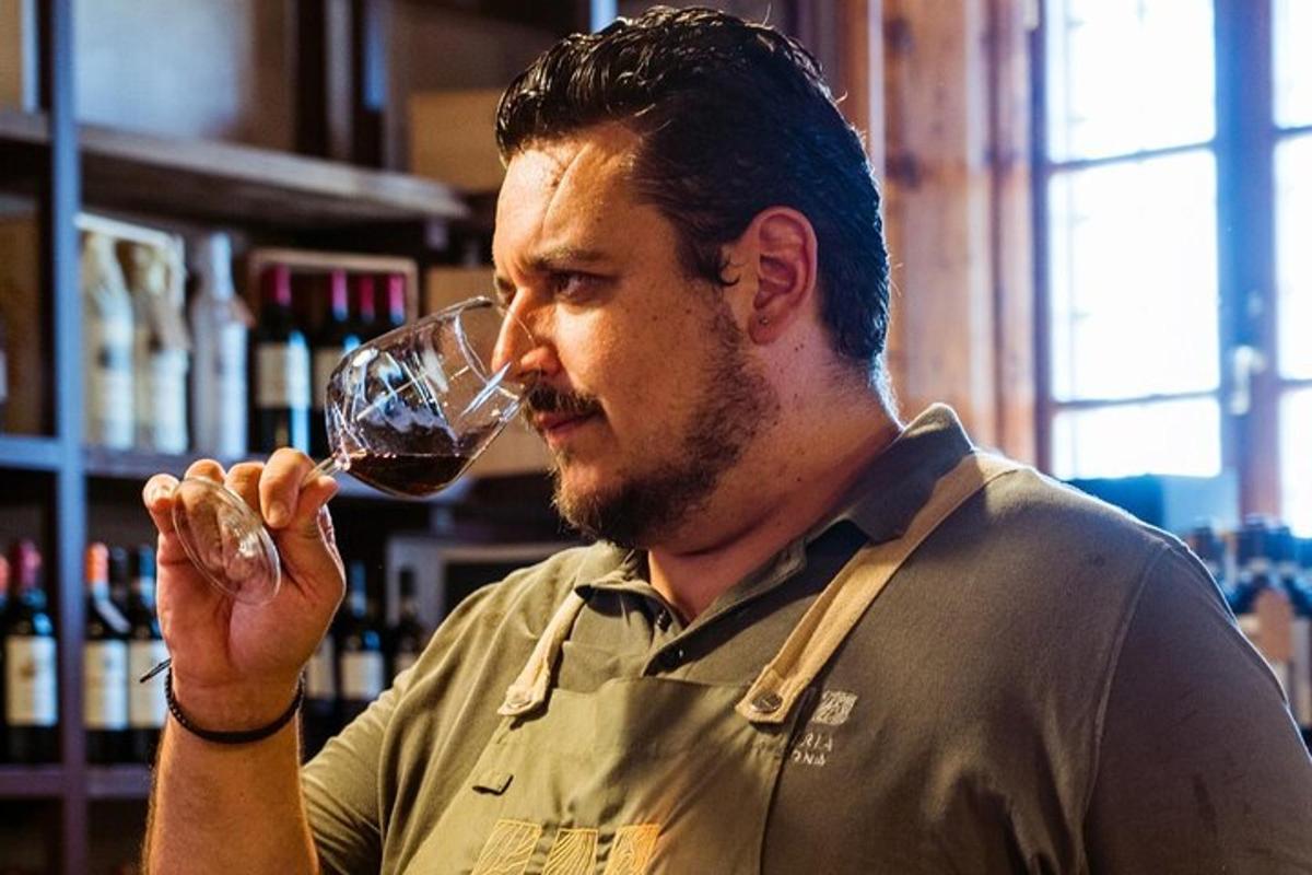 un bărbat care bea un pahar de vin roșu