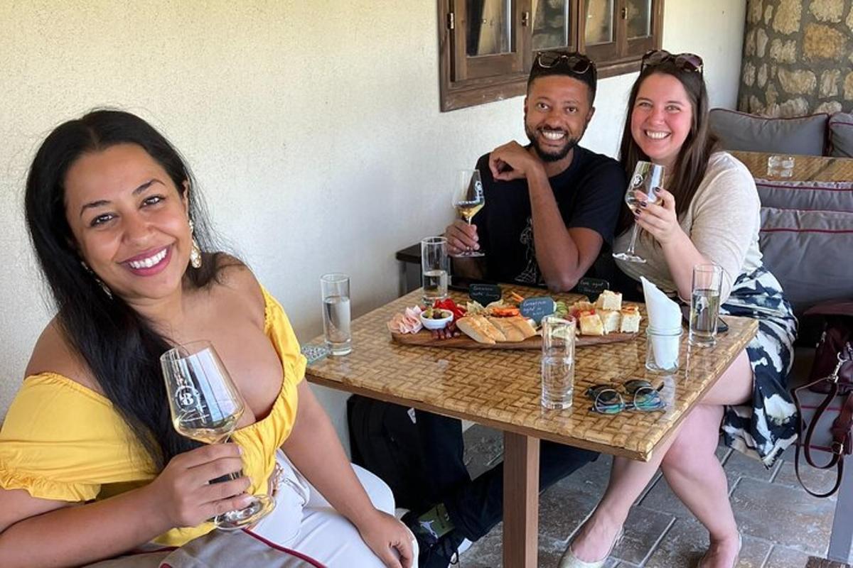 um grupo de pessoas sentadas à mesa com taças de vinho