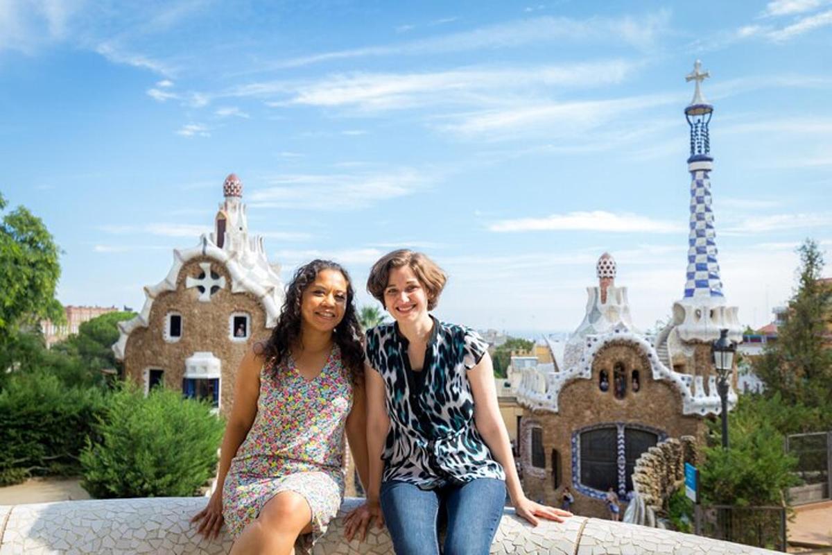 two women sitting on a wall in front of a castle