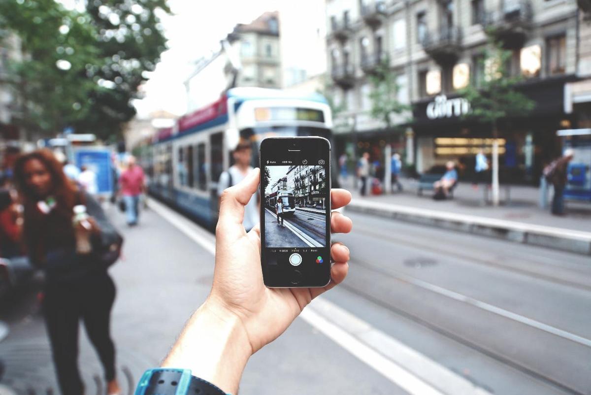 a person taking a picture of a street with a cell phone