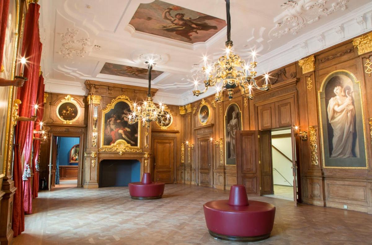 a room with wood paneling and a chandelier