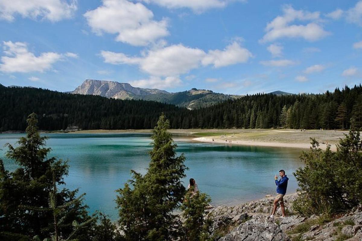 doi oameni care stau pe malul unui lac