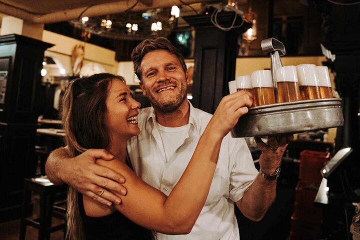 un uomo e una donna che tengono un vassoio di birra