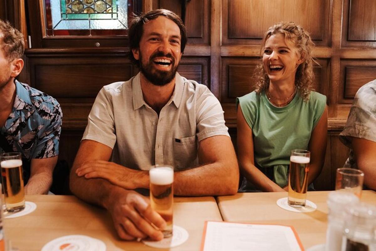 un uomo e una donna seduti a un tavolo con una birra