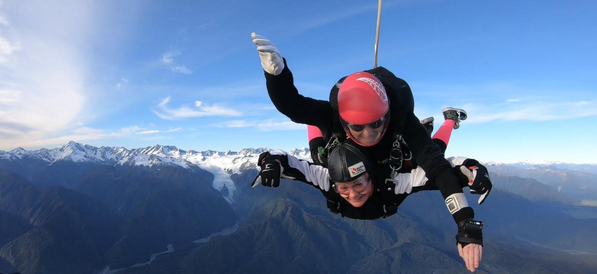 Dos personas están colgadas de la cima de una montaña.