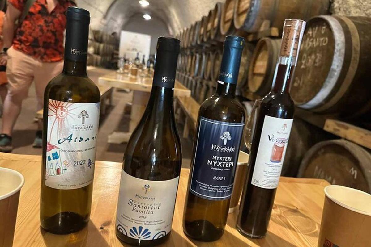 Τρία μπουκάλια κρασί κάθονται σε ένα ξύλινο τραπέζι