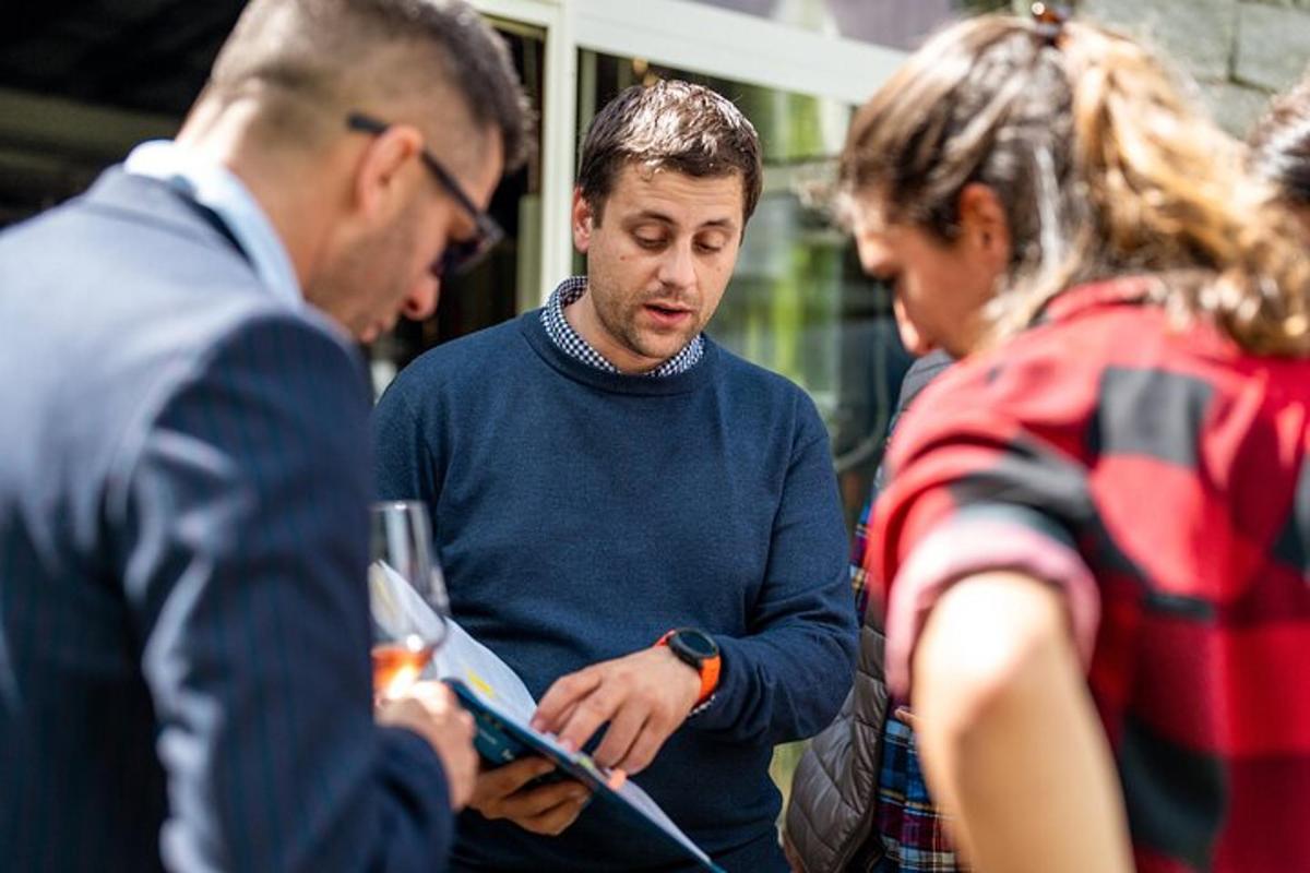 Μια ομάδα ανθρώπων που στέκονται γύρω από έναν άνδρα με μια ταμπλέτα