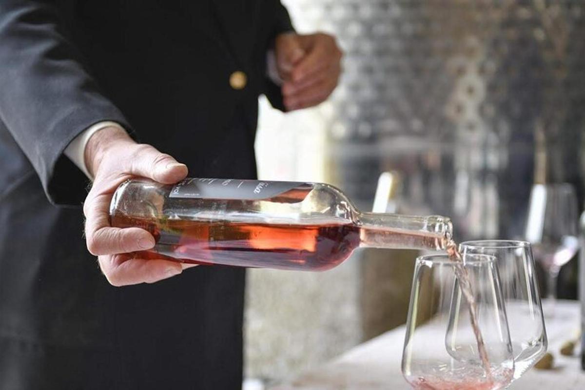 un uomo che versa il vino in un bicchiere da vino