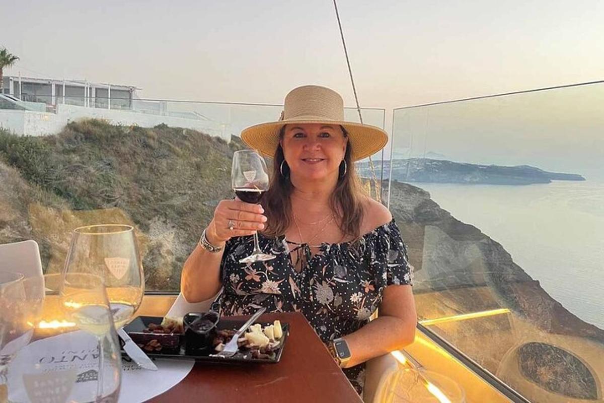 a woman sitting at a table with a glass of wine