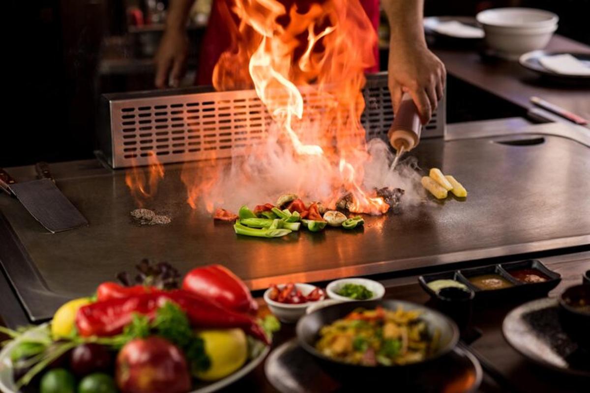 en person, der laver mad på en grill med ild