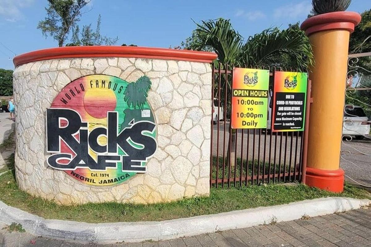 dinding batu dengan tanda di sebelahnya di sebelah pagar