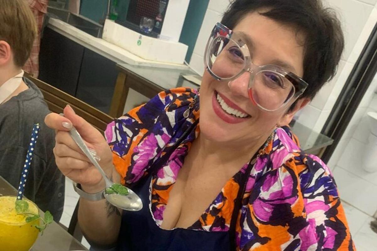 eine Frau mit Brille hält einen Löffel und ein Getränk