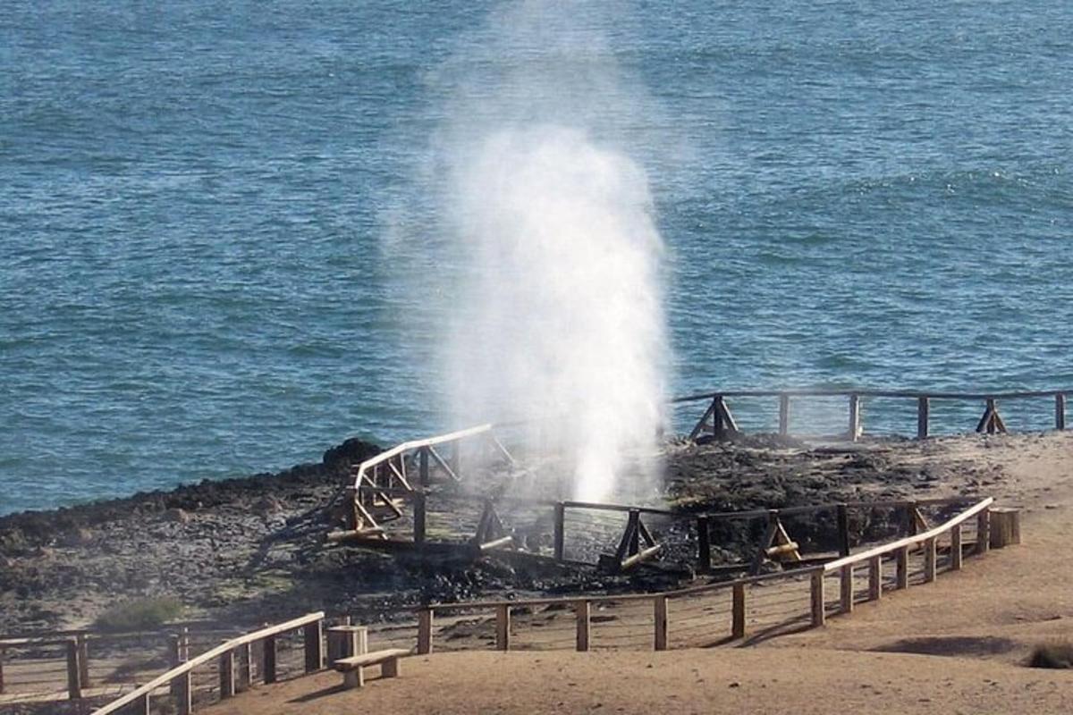 um hidrante jorrando água em uma praia