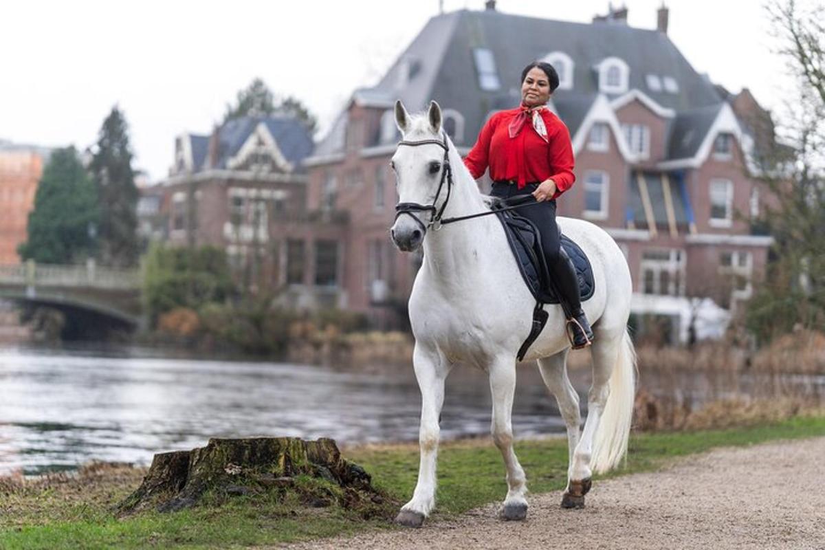 a woman riding a white horse on a path