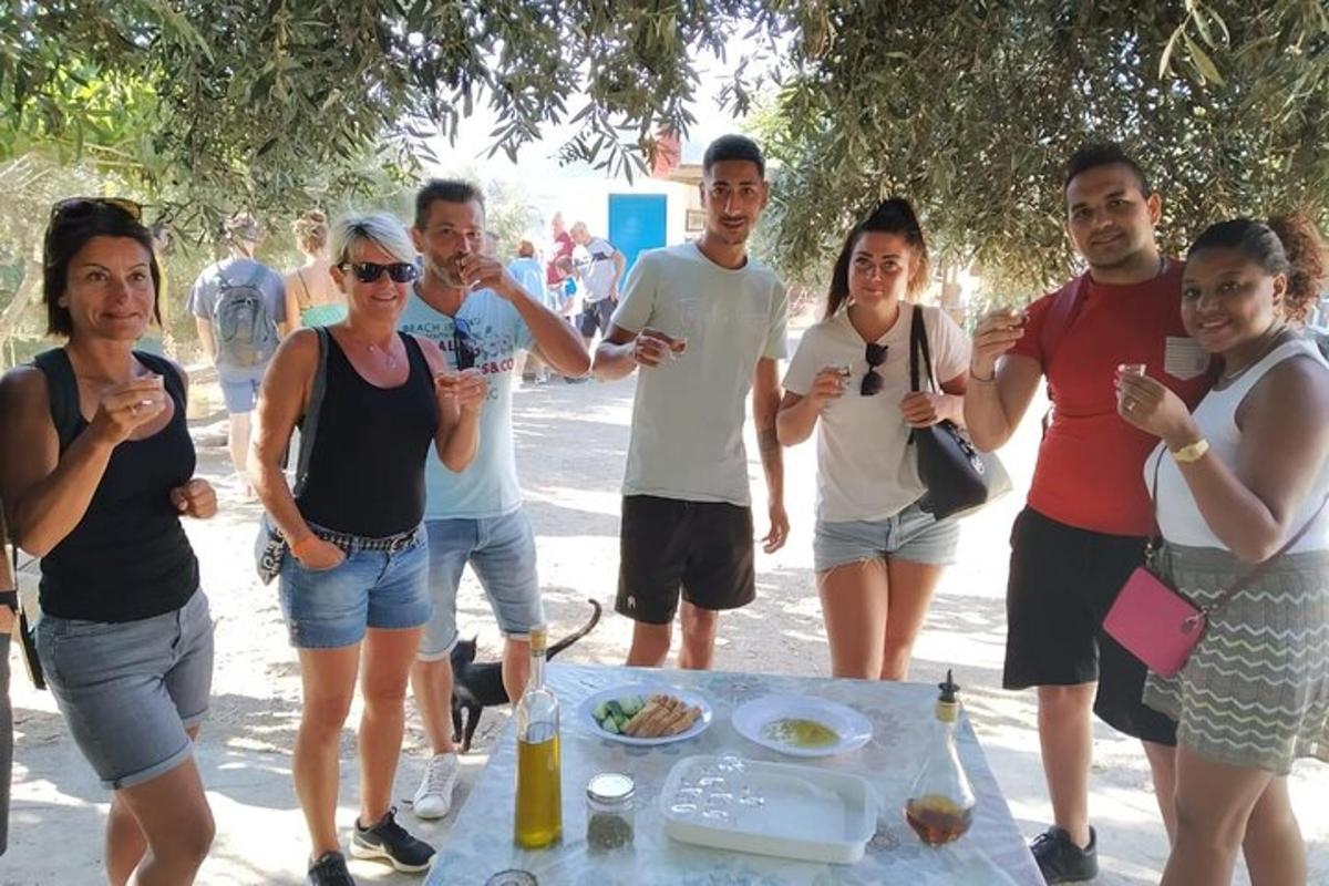 um grupo de pessoas em pé ao redor de uma mesa de piquenique