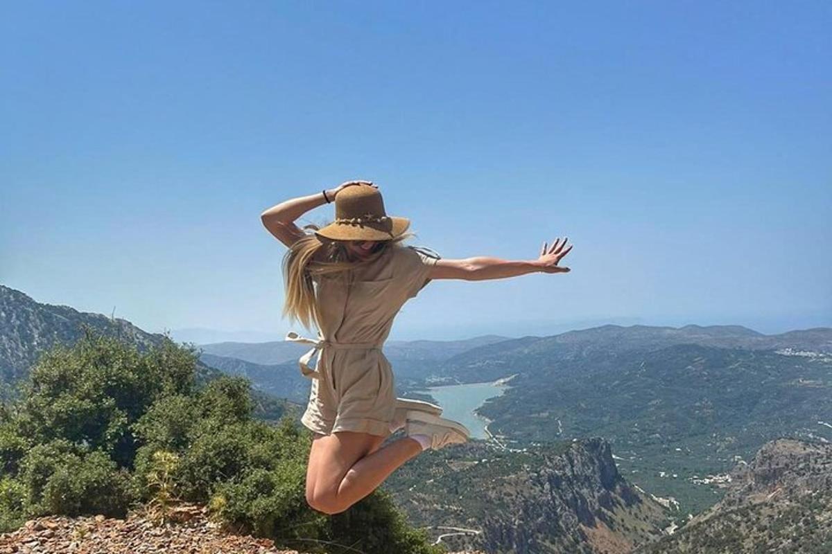 žena skače u zrak na vrhu planine