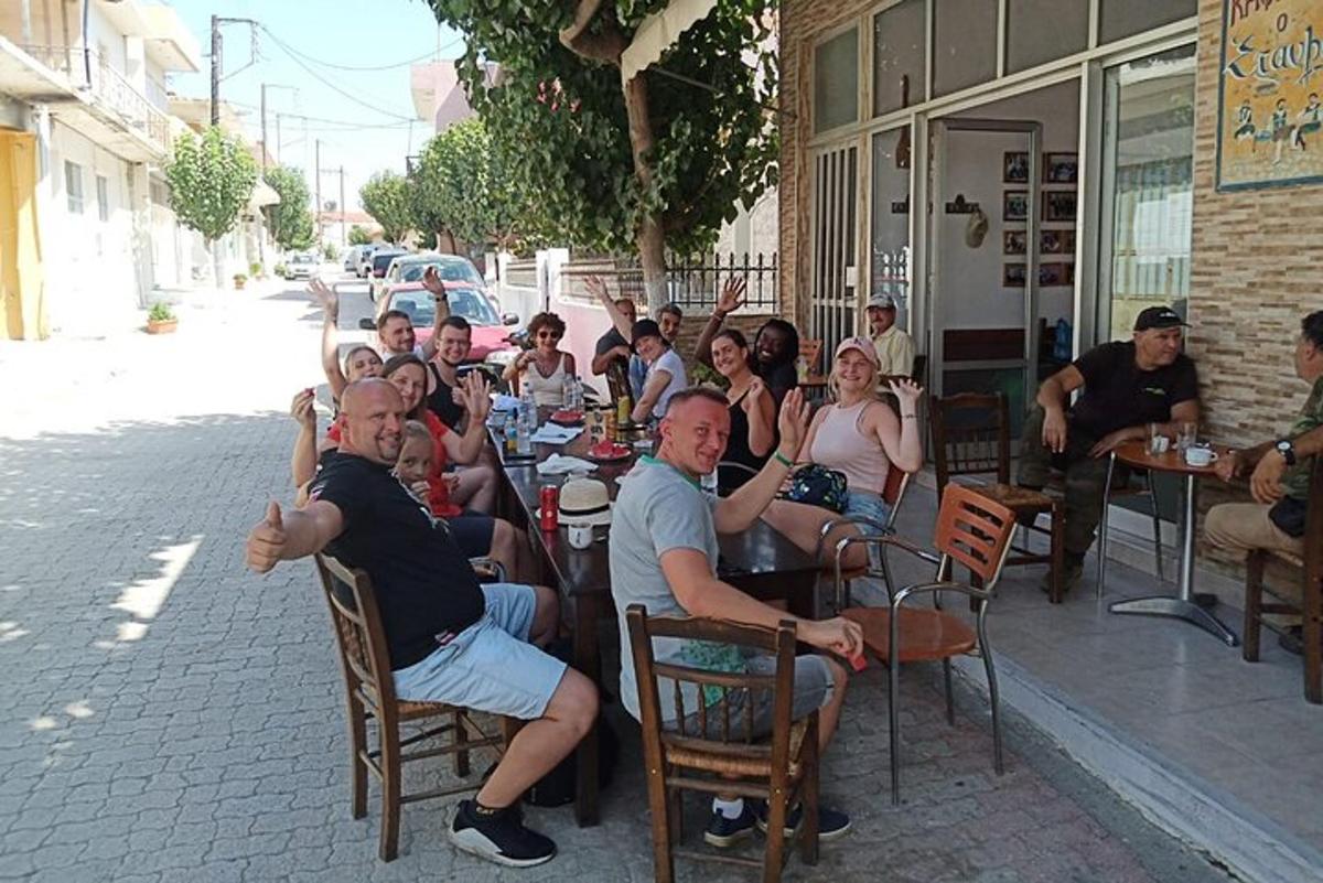 un grup de oameni așezați la mese în fața unui restaurant