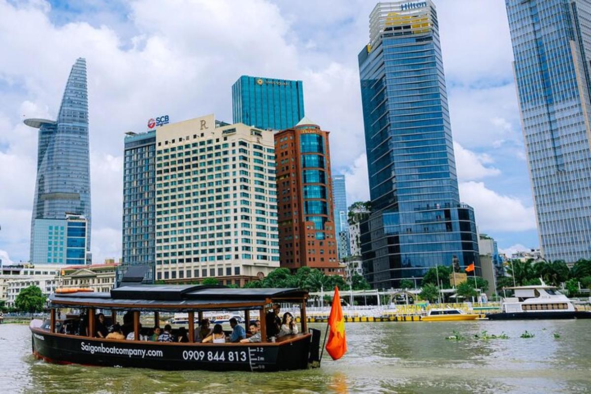 Un barco lleno de gente en un río en una ciudad.