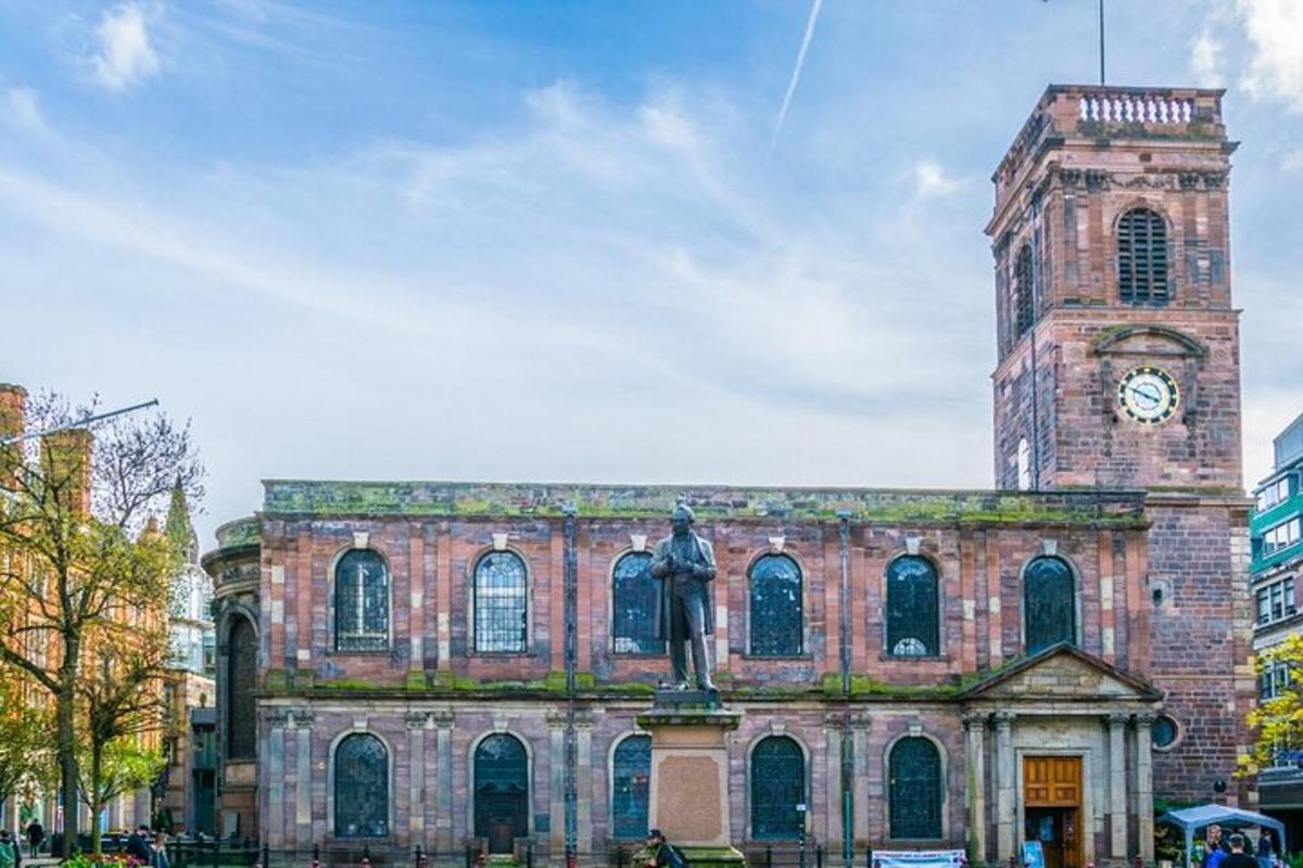 um edifício com uma estátua na frente e uma torre do relógio