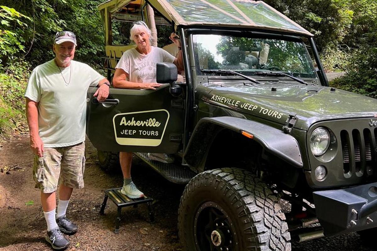 two men are standing next to a green jeep
