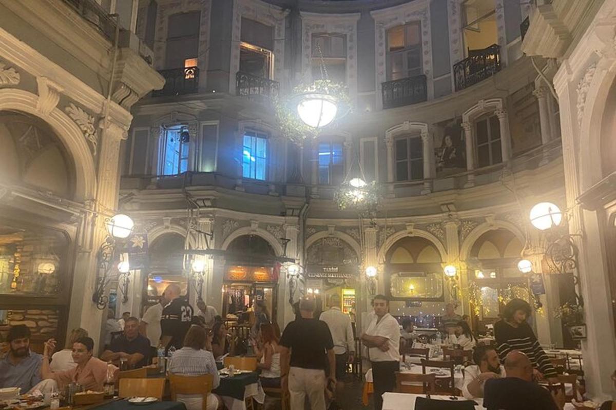 un grup de persones assegudes a taules en un edifici