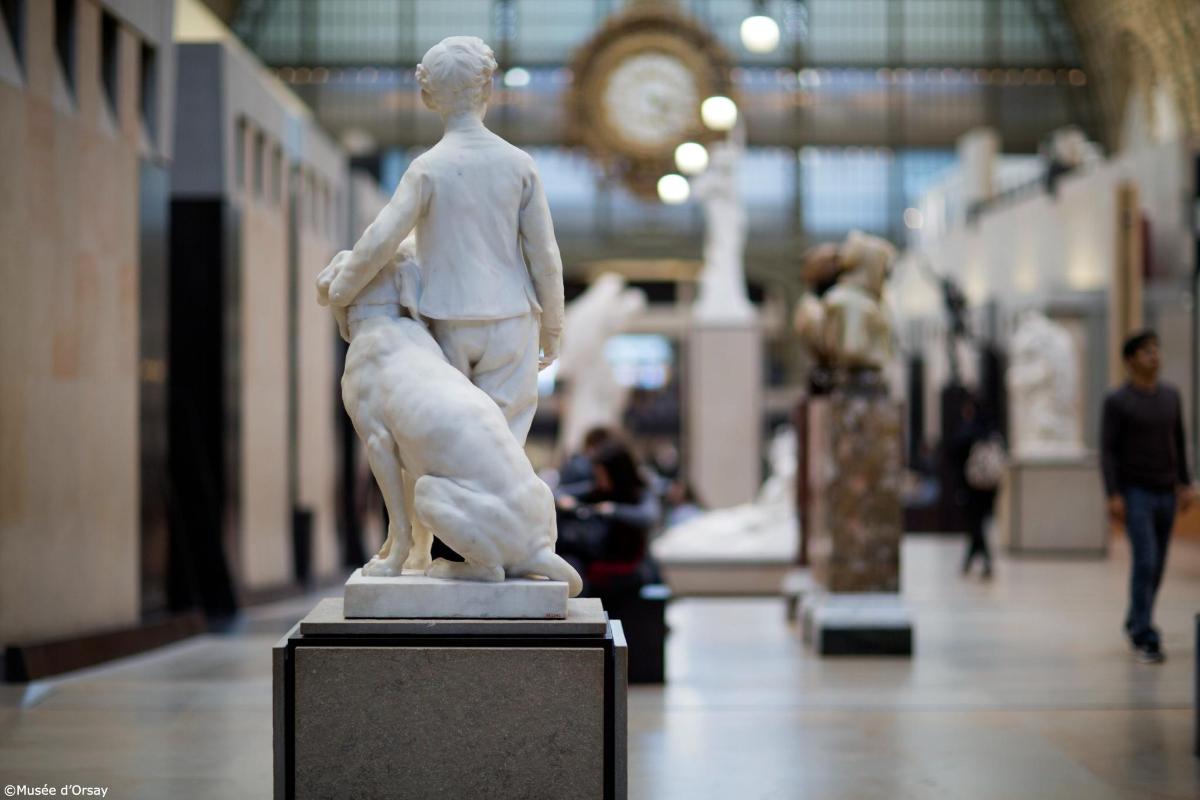 a statue of a man with a dog in a museum